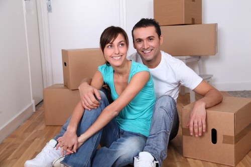 Removal team handling belongings in a North London flat with careful loading