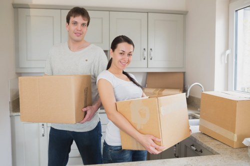 Movers carrying a sofa through a stairwell in a typical Archway apartment building